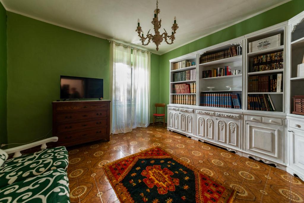 a green room with a bedroom with a dresser and book shelves at La casetta colorata in Civitavecchia