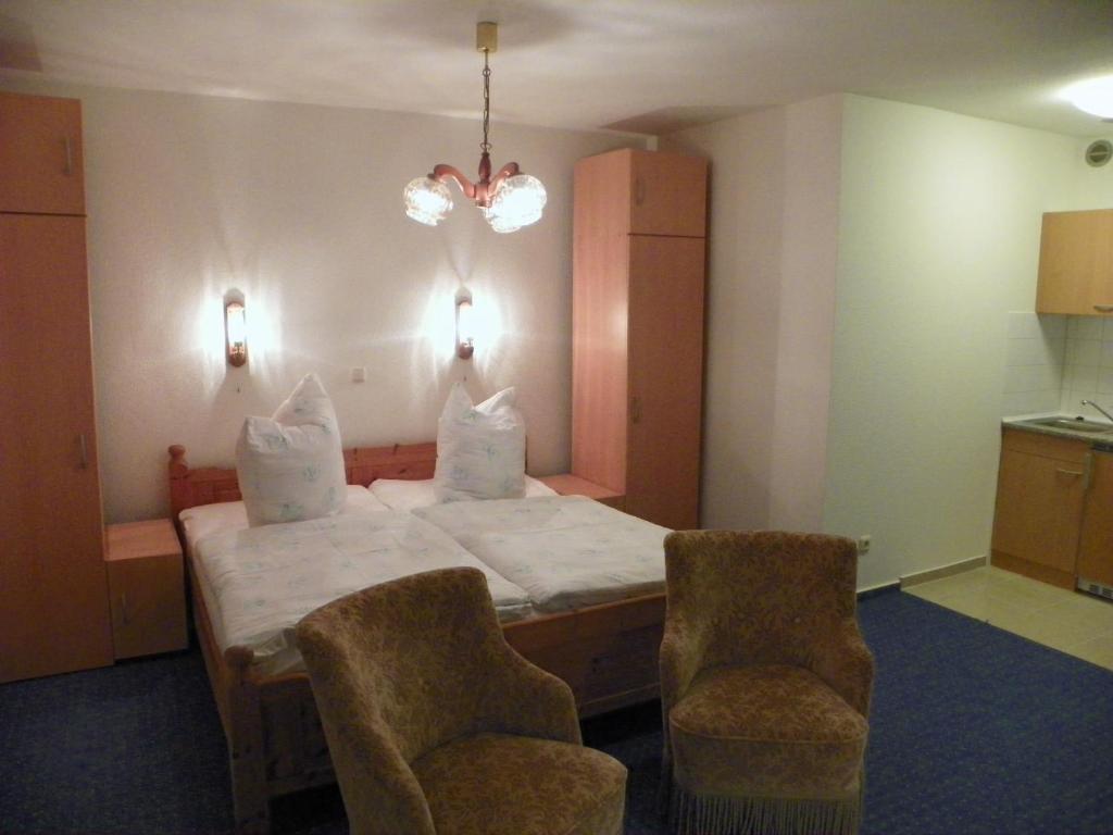 a bedroom with a bed and two chairs in it at Gemütlich privat allergiearm in Timmendorfer Strand