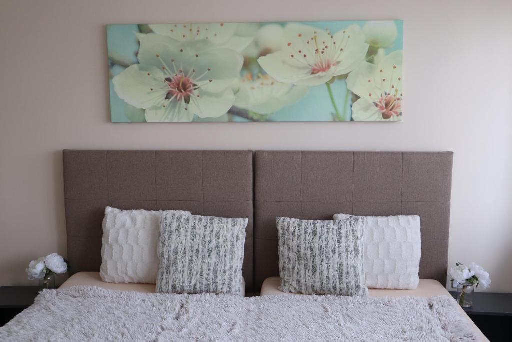 Un dormitorio con una cama con una pintura encima. en Villa Relax KomfortLak, en Gárdony