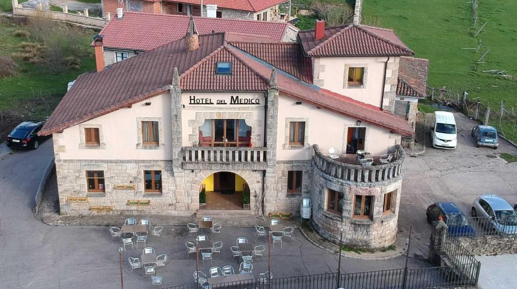 a building with a lot of chairs in front of it at Hotel Rural del Médico in Regumiel de la Sierra