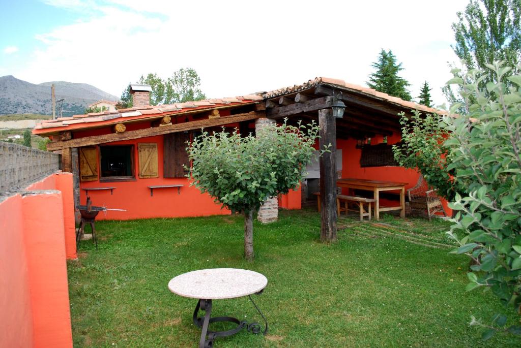 une petite maison avec une table dans la cour dans l'établissement El Uncar, à Castrejón de la Peña