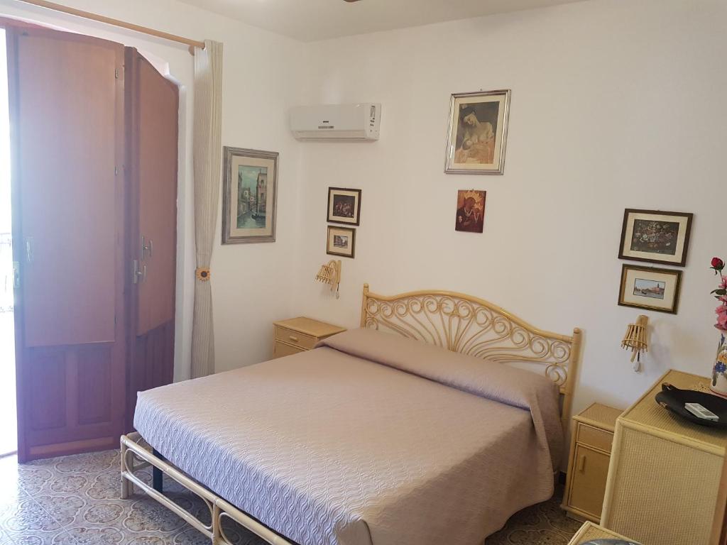 a bedroom with a bed and a door to a room at Villa del Golfo Urio with swimming pool shared by the two apartments it is essential to have a car in Santa Flavia