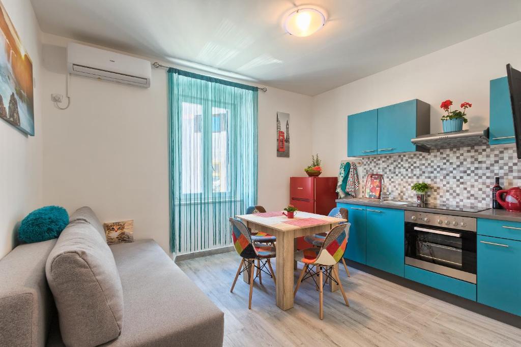 a living room with a couch and a table in a kitchen at Apartment Amfiteatar Moris in Pula
