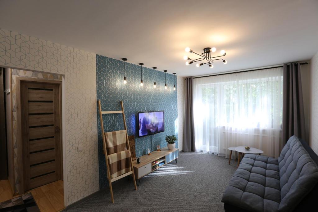 a living room with a couch and a chandelier at Delightful Apartment - FREE PARKING - NETFLIX in Kaunas