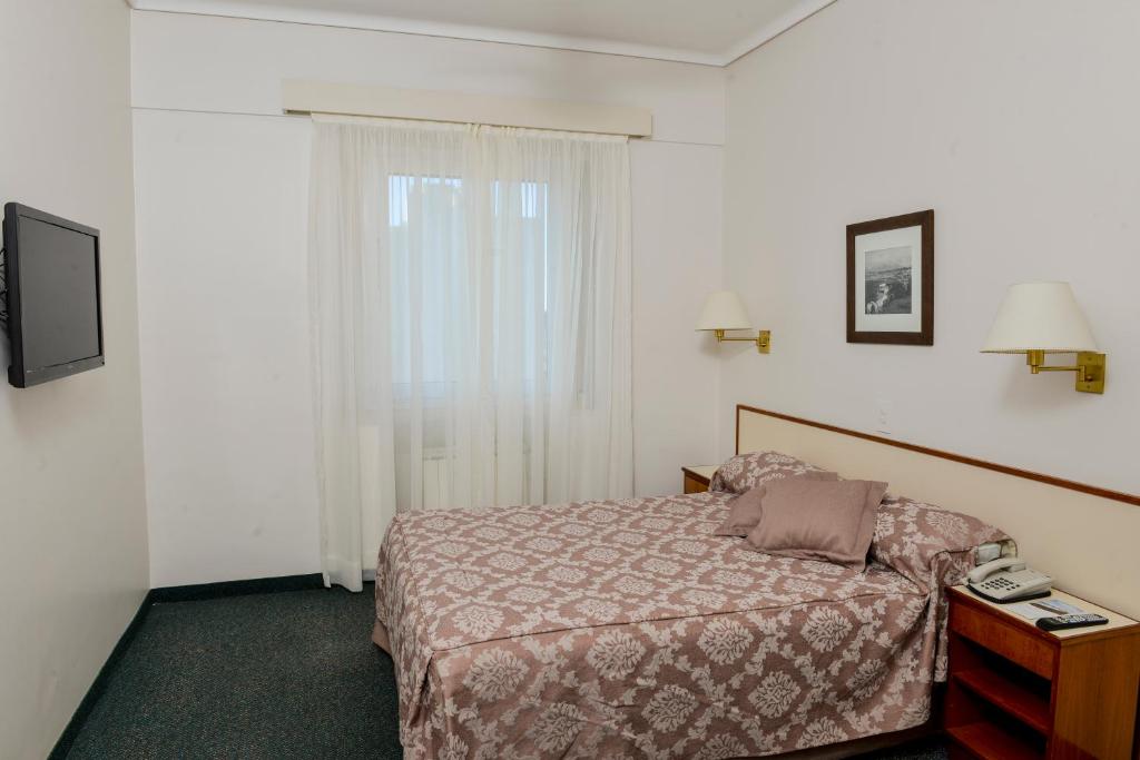 a hotel room with a bed and a telephone at Comodoro Hotel in Comodoro Rivadavia