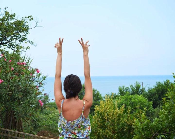 a woman standing with her hands in the air at Jintcharadze Inn in Makhinjauri