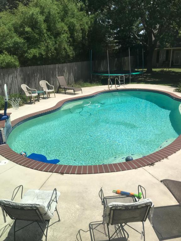 einen großen Pool mit Stühlen und einem Tisch in der Unterkunft Backyard Cottage in Lafayette