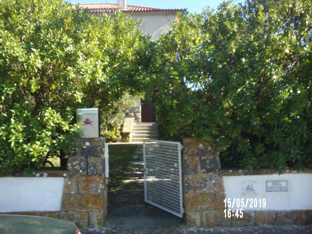 um portão em frente a uma casa com árvores em Boa Vivenda em Carcavelos