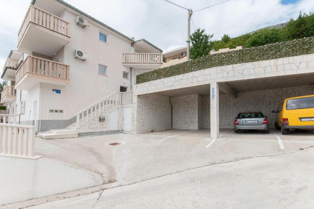 un edificio con un coche aparcado en un aparcamiento en Apartmani Vesna en Celina