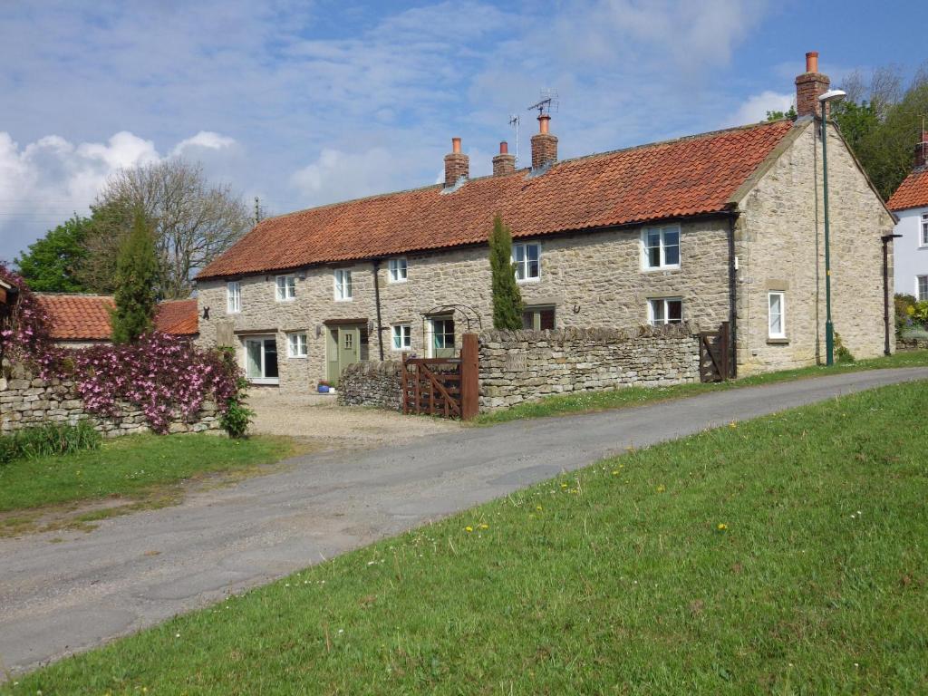 a group of stone houses with a road at Pond Farm in Pickering