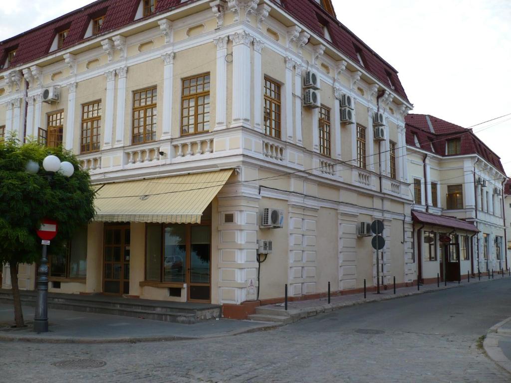 un grande edificio bianco sul lato di una strada di Hotel Regal a Brăila