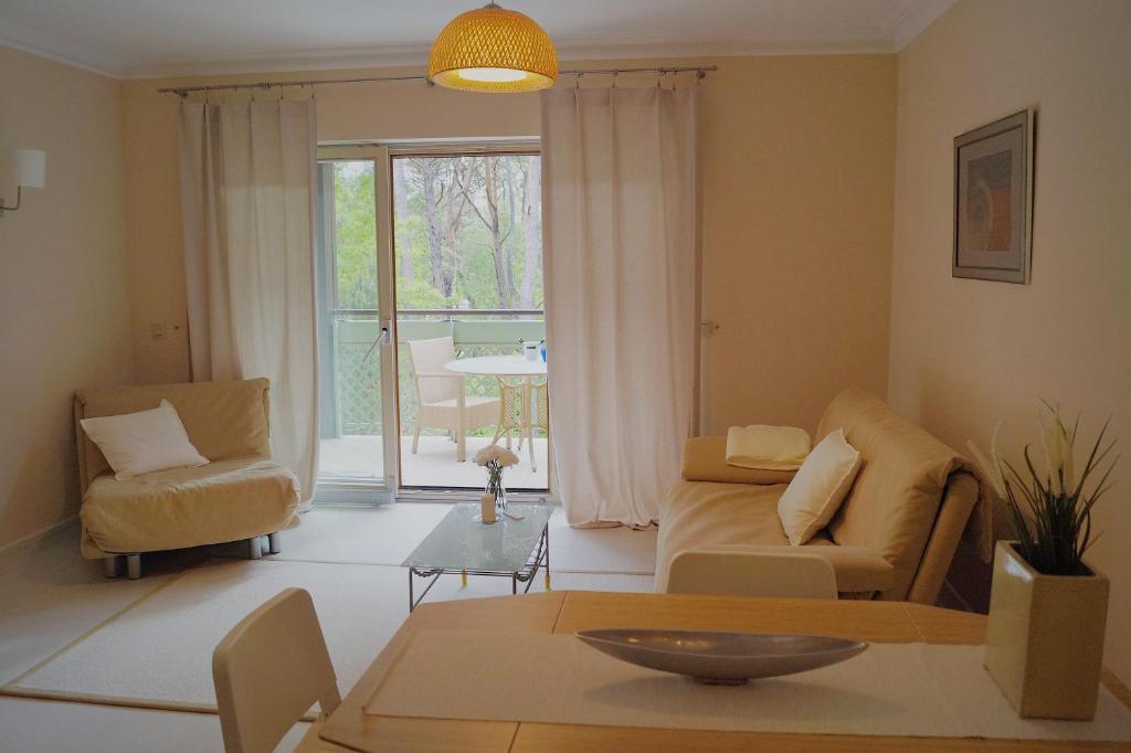 ein Wohnzimmer mit einem Sofa, Stühlen und einem Tisch in der Unterkunft Apartament przy morzu Rezydencja Bryza in Jurata