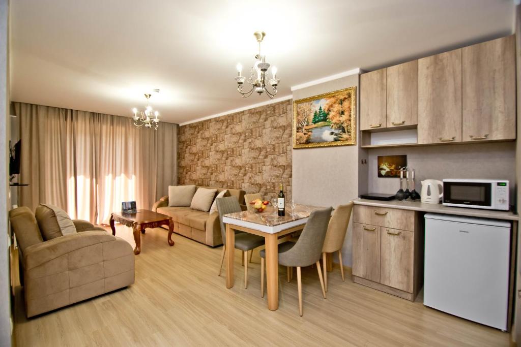 巴庫里阿尼的住宿－Orbi Bakuriani apartment 731，厨房以及带桌子和沙发的客厅。