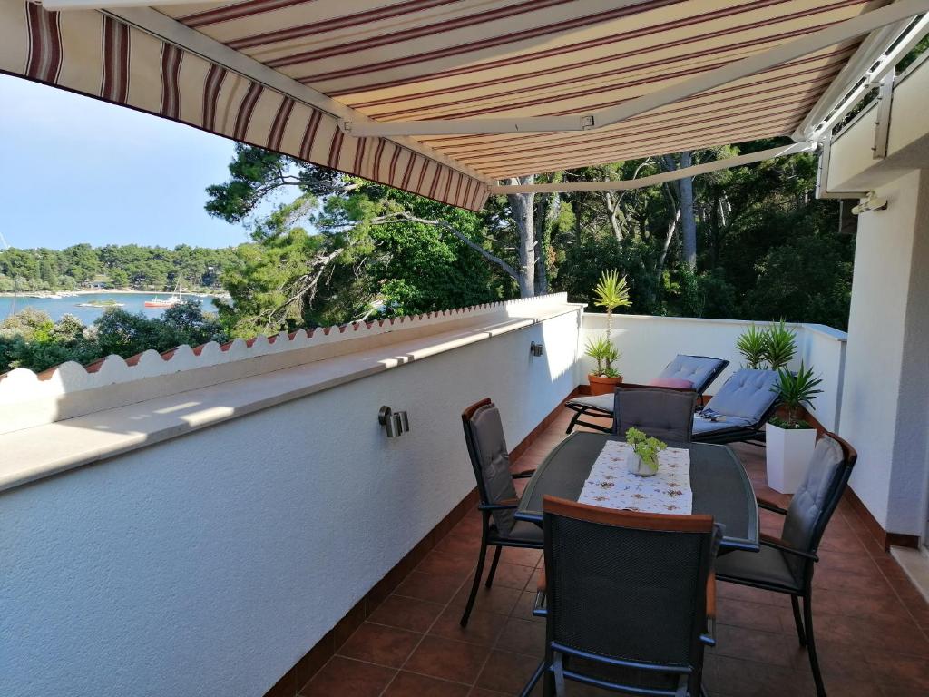 patio con mesa y sillas en el balcón en Apartment Markorcula, en Korčula