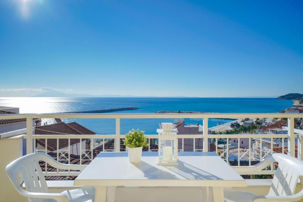 a white table and chairs on a balcony with the ocean at Villa Margarita in Limenaria
