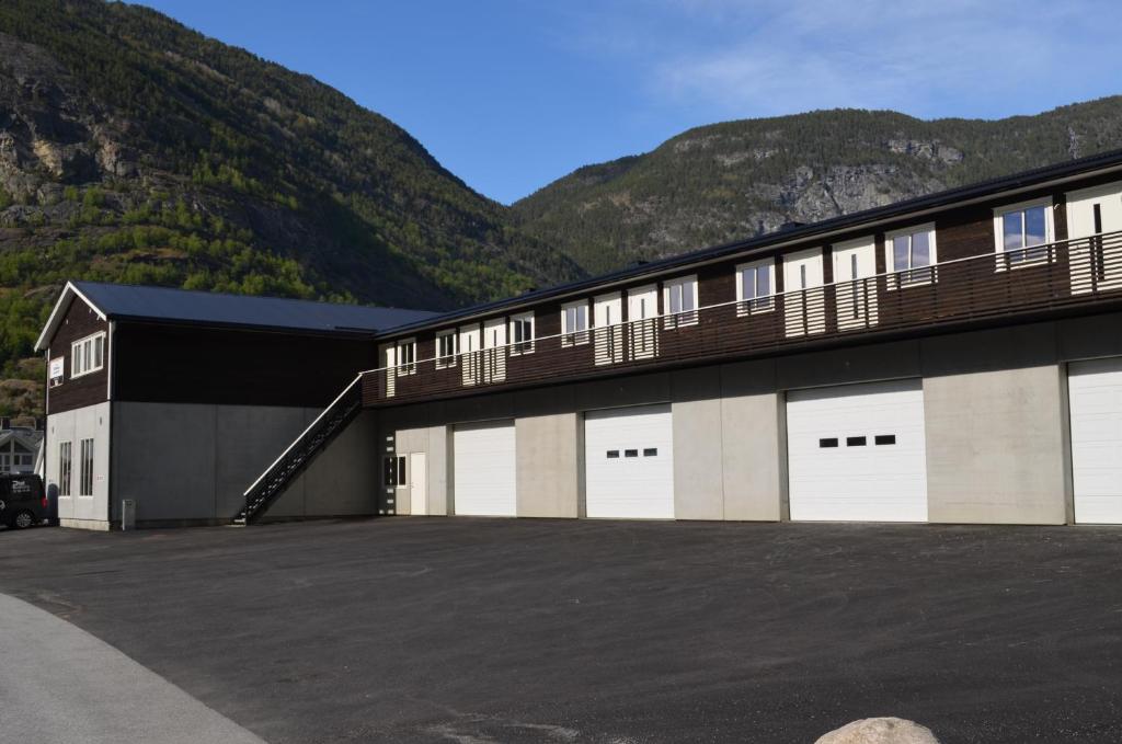 un edificio con puertas blancas de garaje con montañas al fondo en Einemo Apartments en Lærdalsøyri