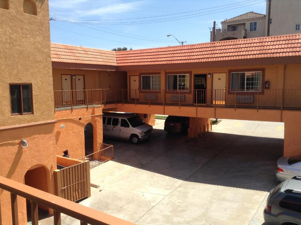 un edificio con un coche aparcado en un aparcamiento en Coast Motel, en Long Beach