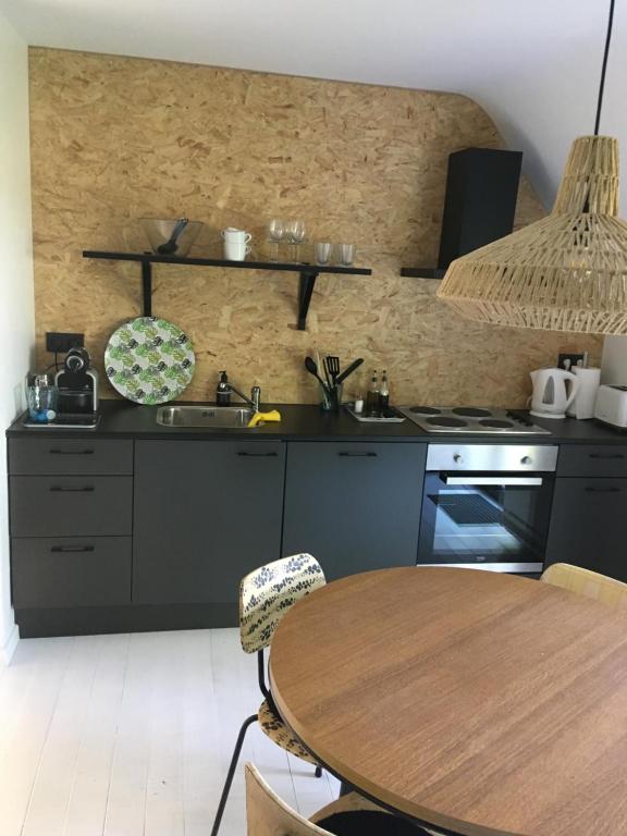 uma cozinha com uma mesa, um lavatório e um fogão em La dreve em Verviers
