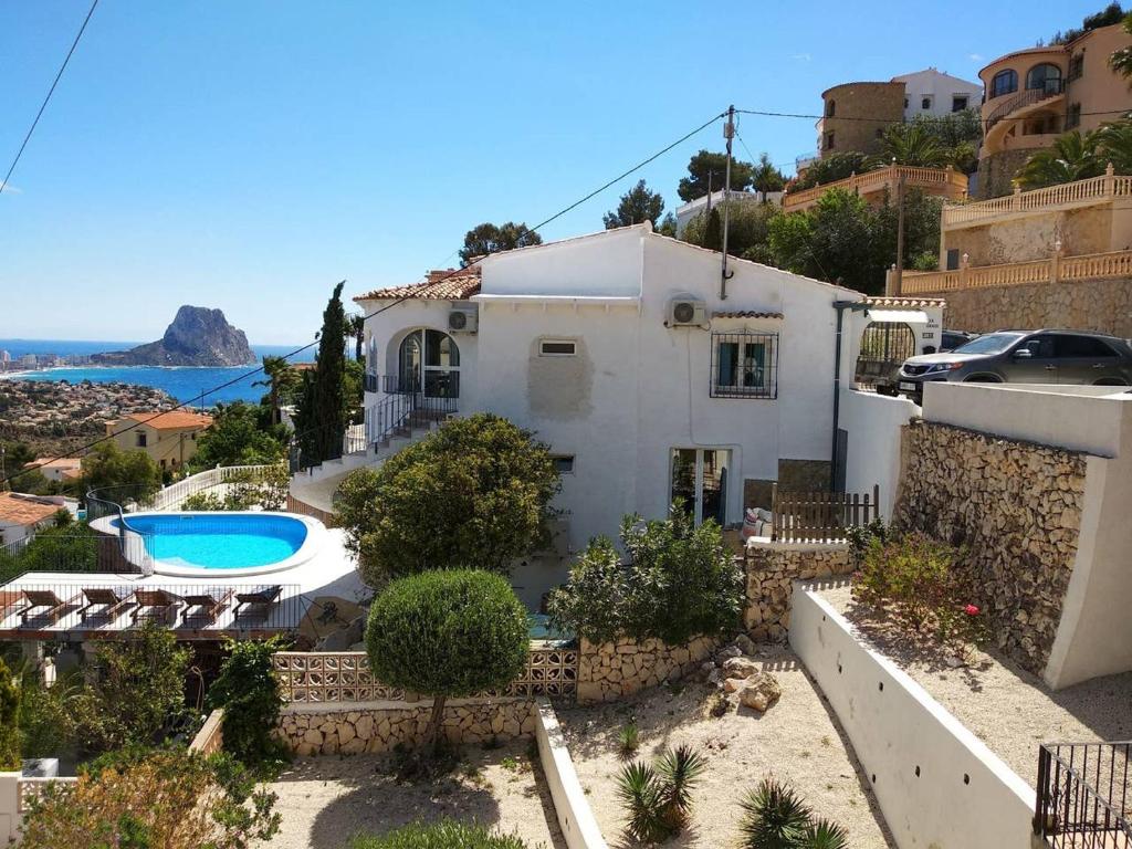 eine Villa mit einem Pool und einem Haus in der Unterkunft villa Grace,10p,seaview,pool in Calpe