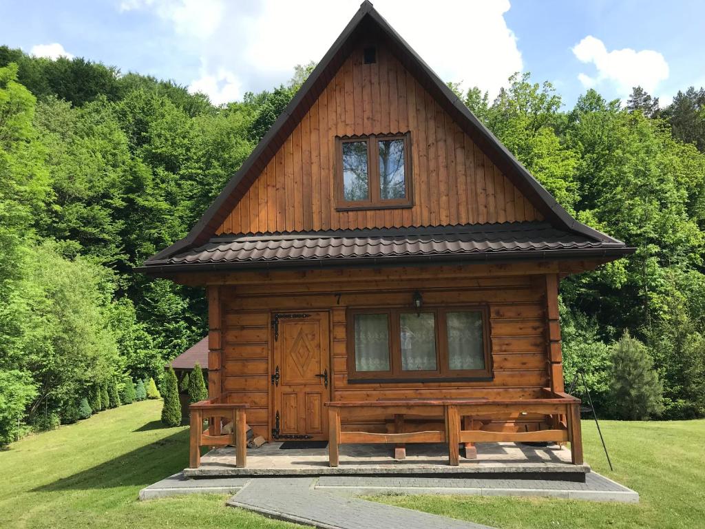 uma cabana de madeira com um telhado inclinado em Ośrodek Niezapominajka em Górzanka