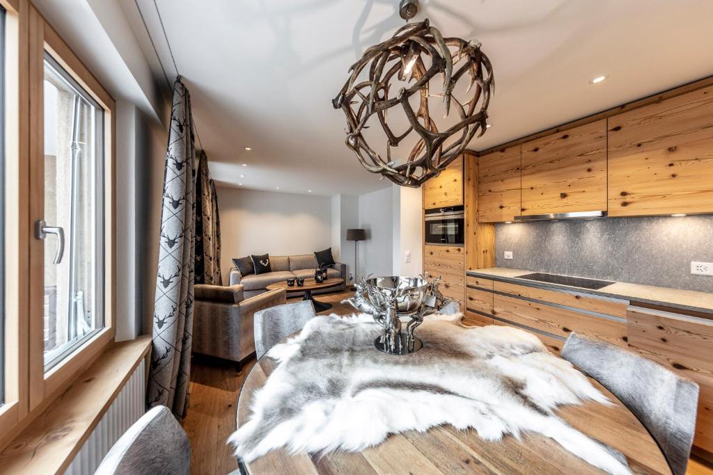 a dining room with a table and a chandelier at Unique Alpic style apartment in the heart of Davos in Davos