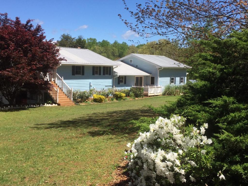 a house with a yard with white flowers at Hidden Valley B&B in Hiawassee