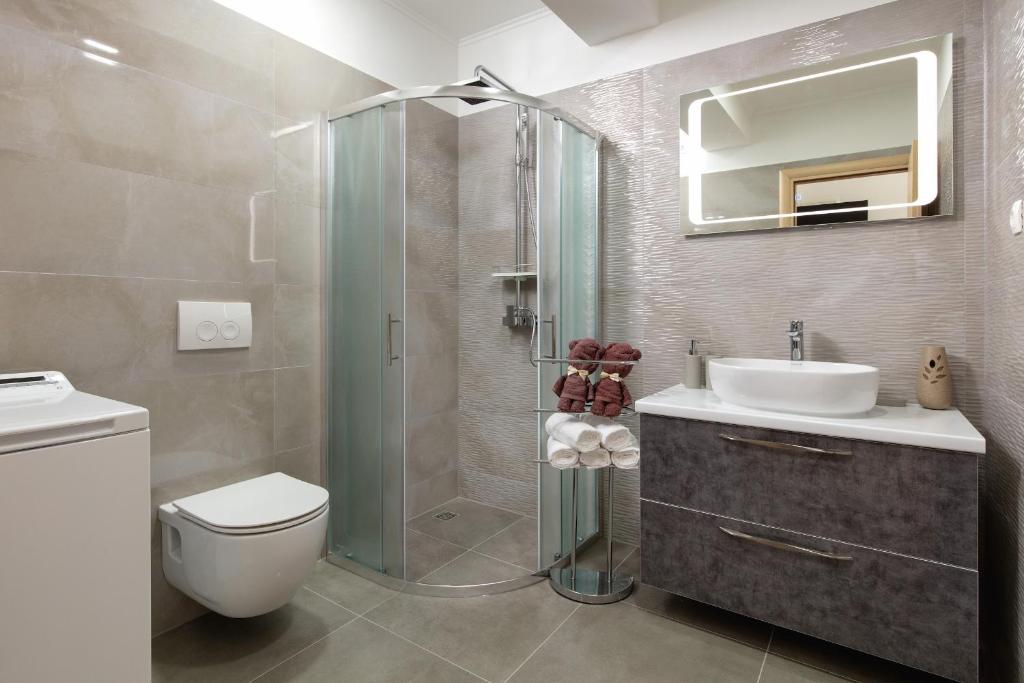 een badkamer met een douche, een toilet en een wastafel bij Villa Apartments Kordić in Kaštela