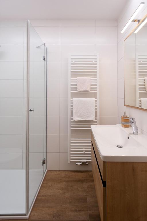 un bagno bianco con doccia e lavandino di Gasthof Fischer Dörnbach a Wilhering