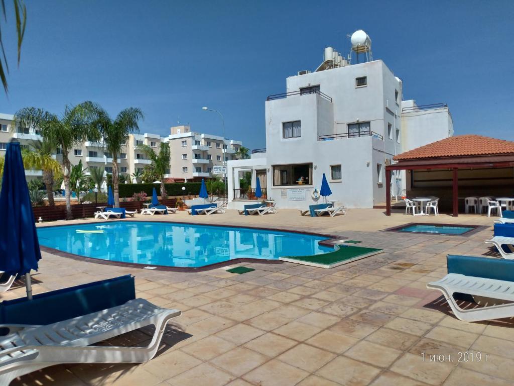 a swimming pool in front of a building at Maricosta Apartments in Protaras