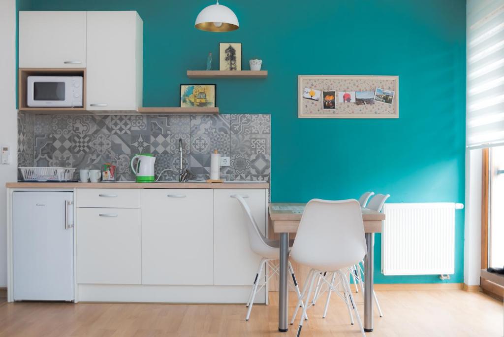 a kitchen with blue walls and a table and chairs at Chikma Apartments in Sarajevo