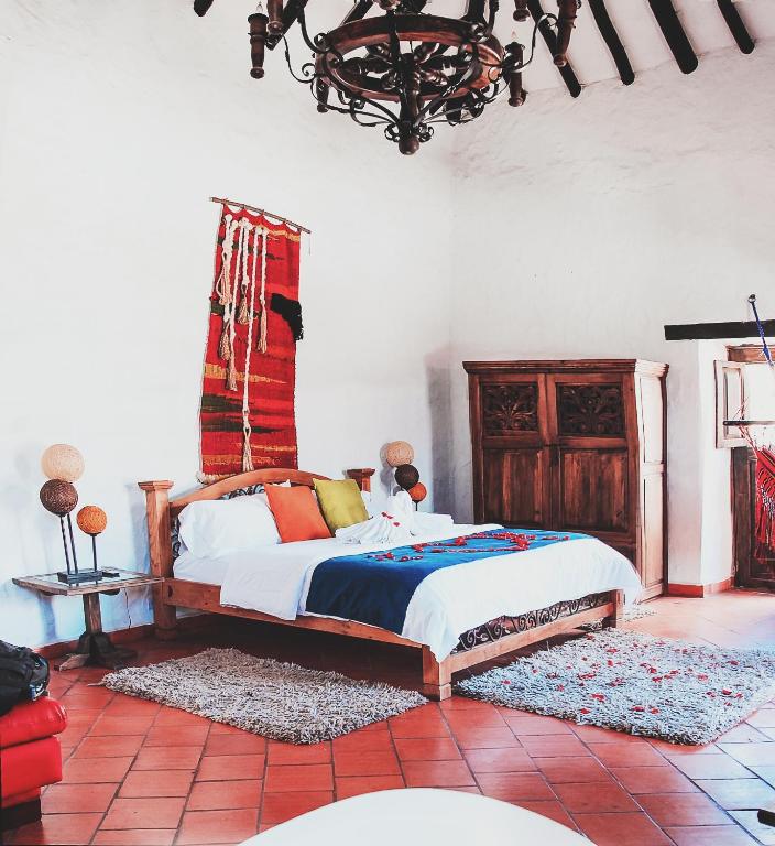 a bedroom with a bed and a chandelier at Casona Quesada in Suesca