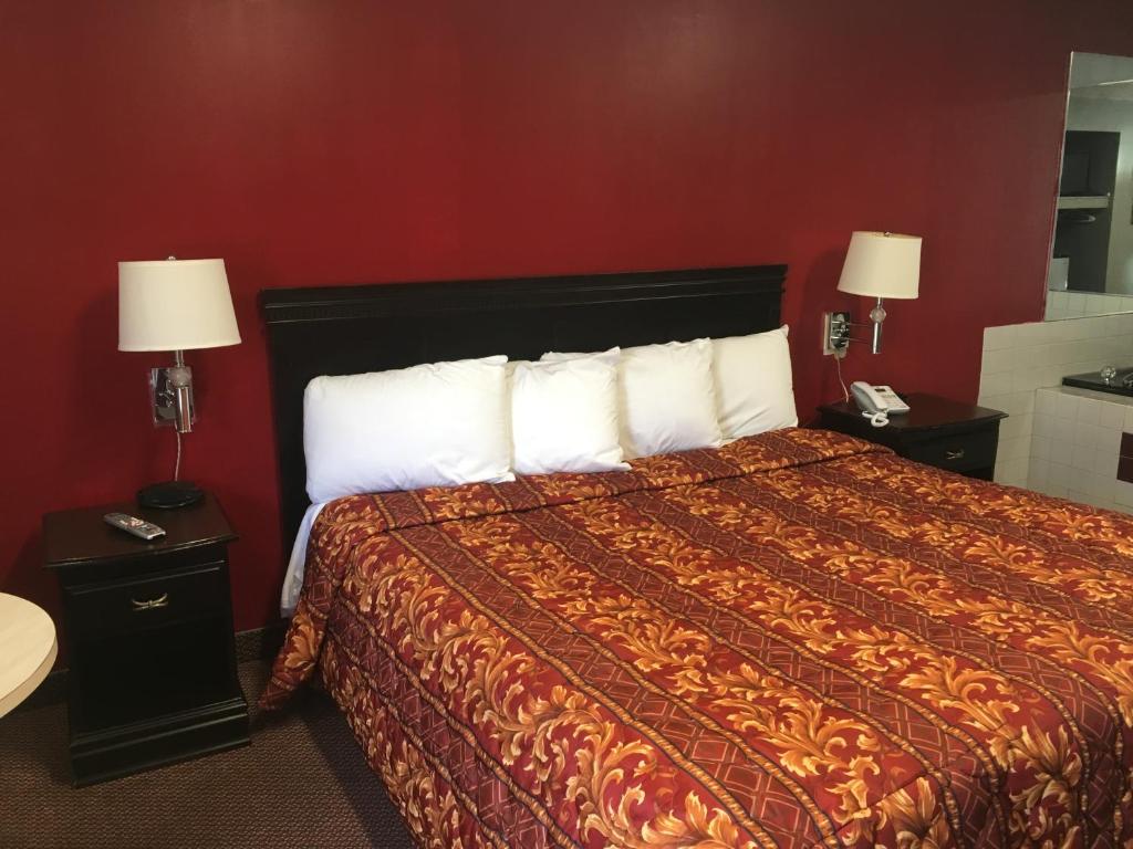 a hotel room with a bed with white pillows at Journeys End Motel in Absecon