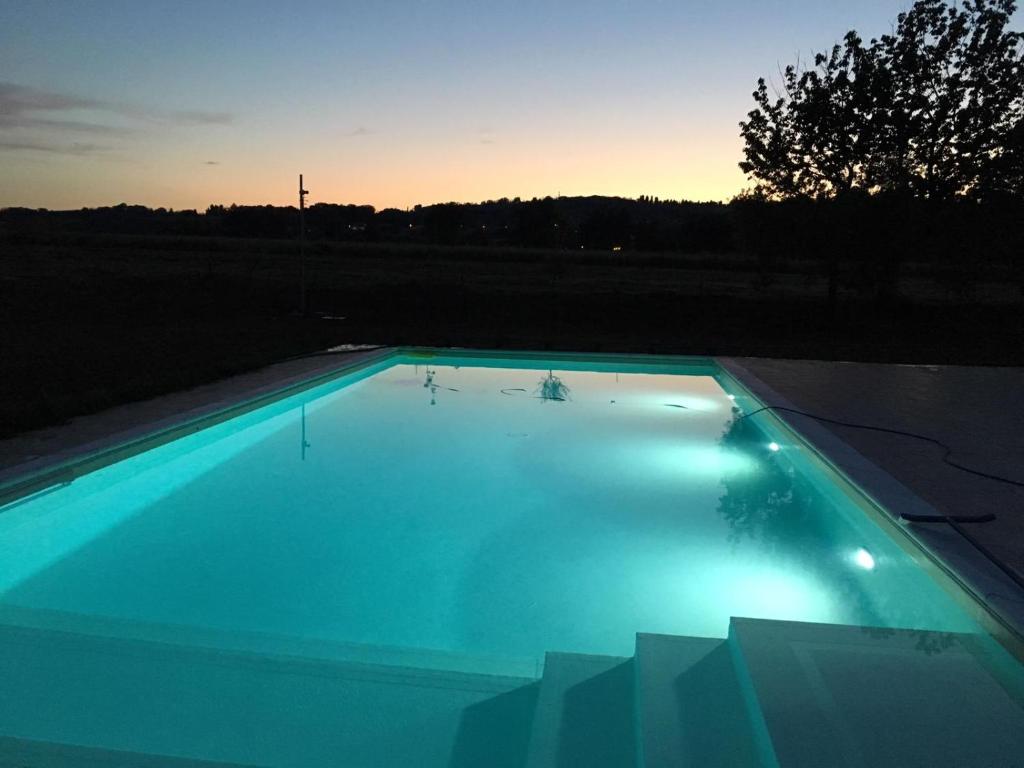 - une piscine d'eau bleue au coucher du soleil dans l'établissement Villa Sofia, à Calcinelli