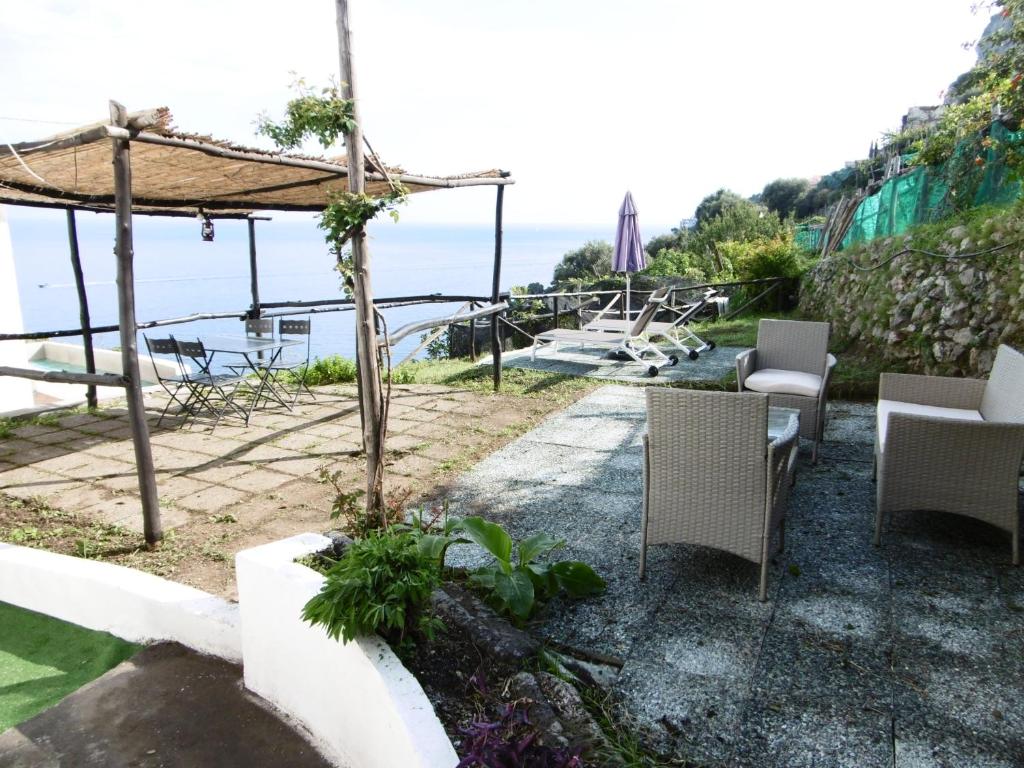 un patio con sillas y vistas al océano en Sea Breeze House, en Amalfi