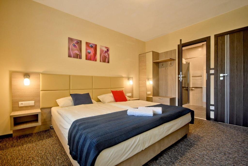 a bedroom with a large bed with blue and red pillows at NA BYSTRYM in Zakopane
