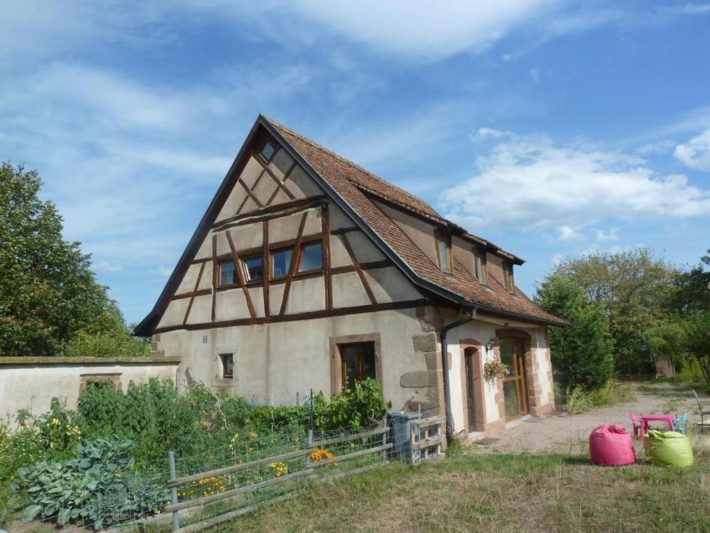 een oud huis met een gambrel dak bij Gite les Cigognes in Neuwiller-lès-Saverne
