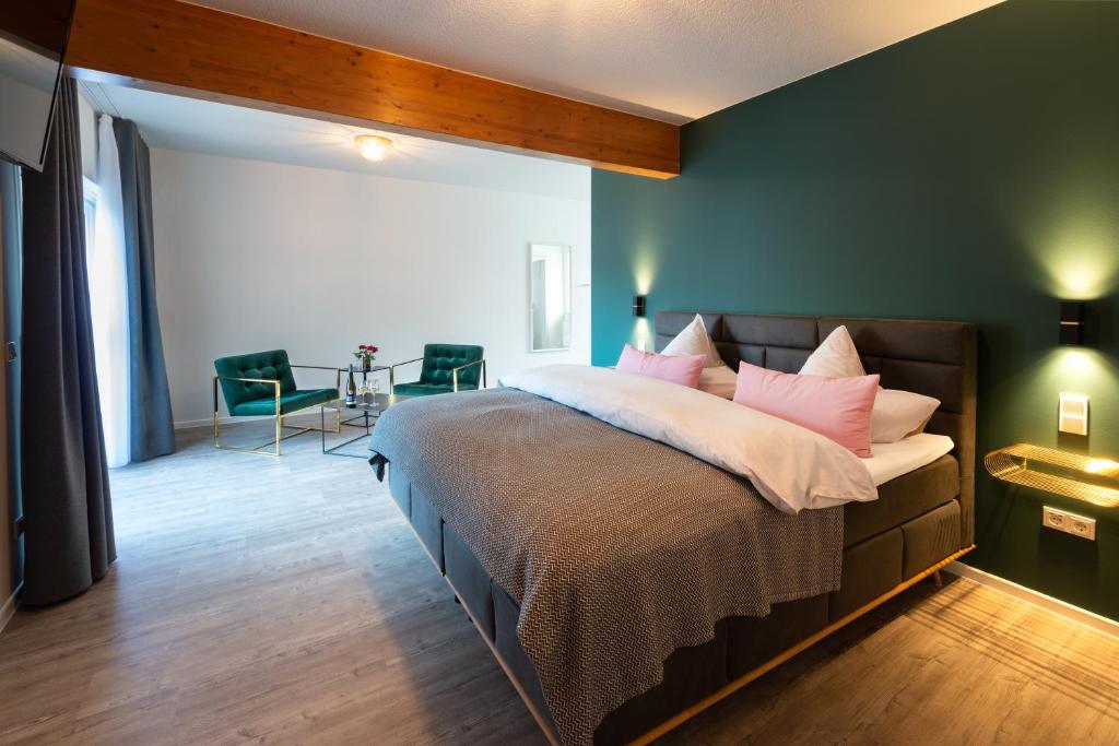 een slaapkamer met een groot bed met roze kussens bij Moselweingut & Gästehaus Hubertushof in Trittenheim