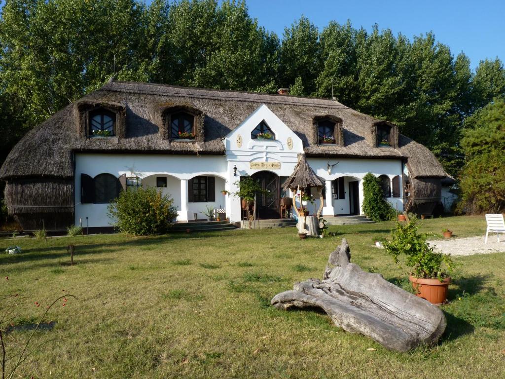 a large white house with a thatched roof at Gedeon Tanya Panzió in Jakabszállás