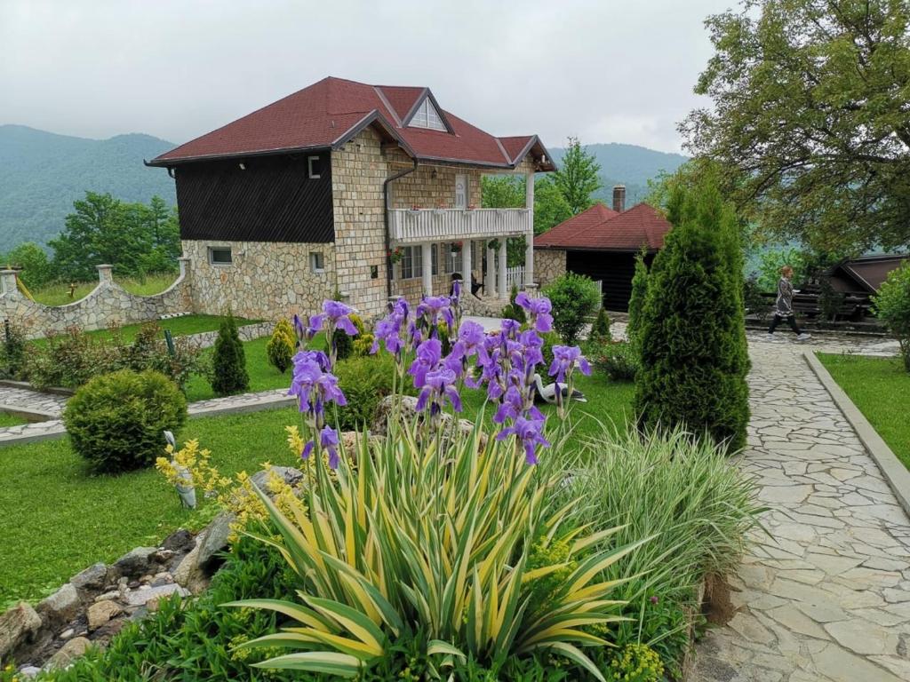 a garden with purple flowers in front of a house at Resort Zafaran by H&H in Sarajevo