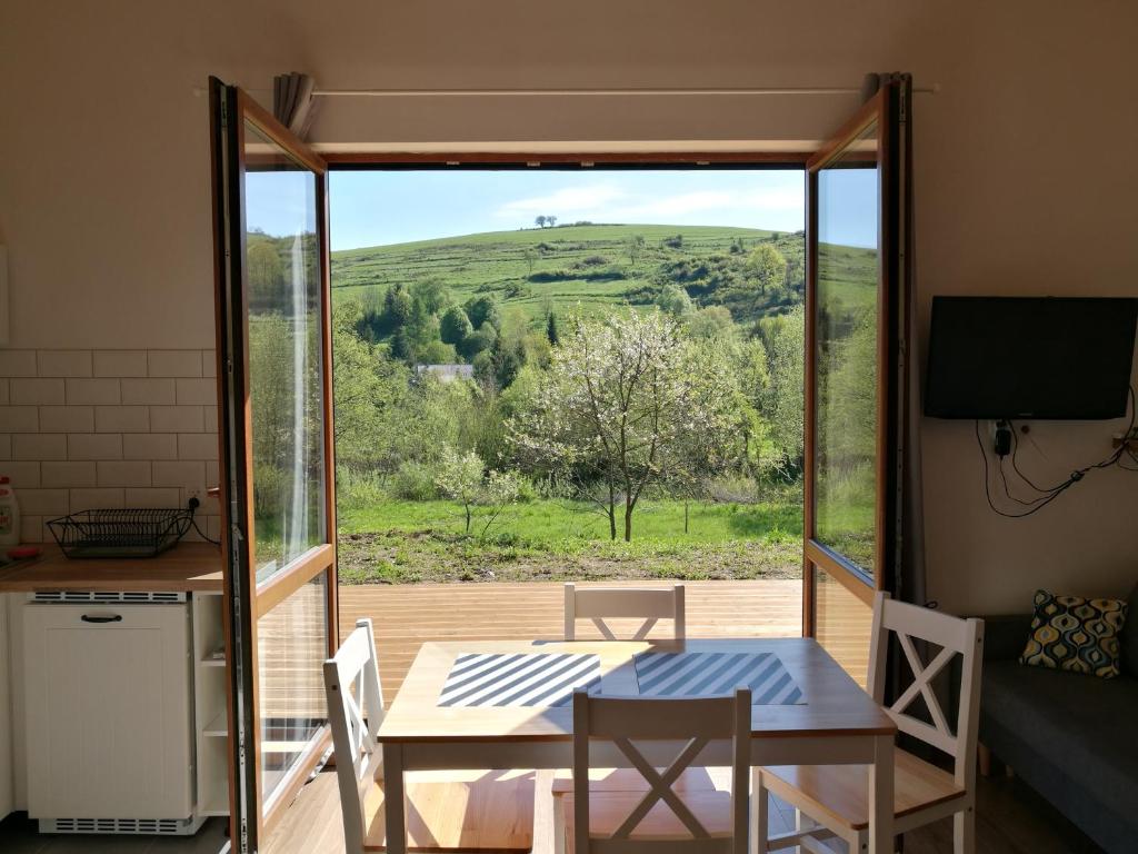 a room with a table and a view of a field at Dobre Miejsce in Ustrzyki Dolne