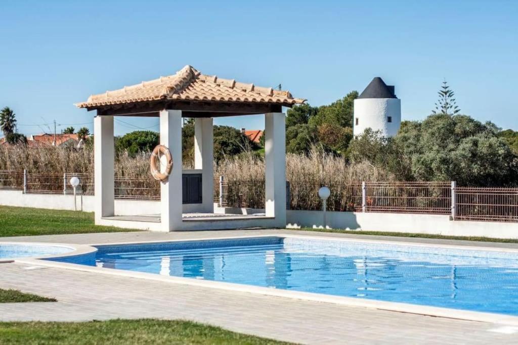 a swimming pool with a gazebo in a yard at Azóia Pool&Garden in Azoia
