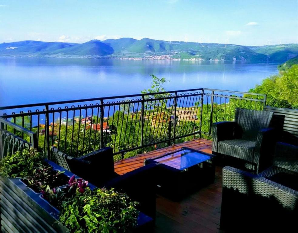 a balcony with chairs and a view of a lake at Carobni breg in Golubac