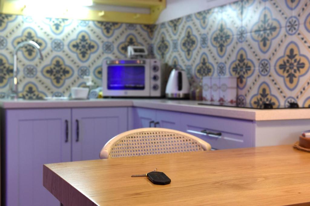a kitchen with a wooden table and a microwave at Sweet Home, Only 7 Min to the beach - By SEAELO EILAT in Eilat