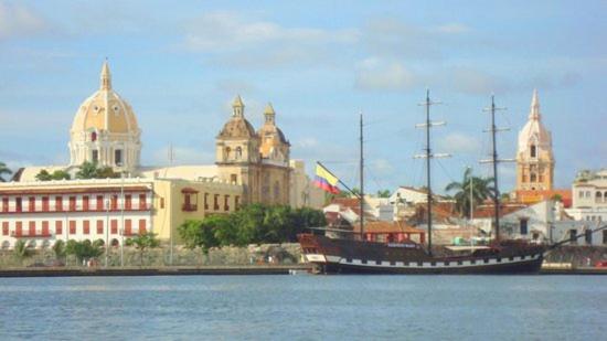 a large boat in the water in front of a city at Hostal Casa de Barajas in Cartagena de Indias