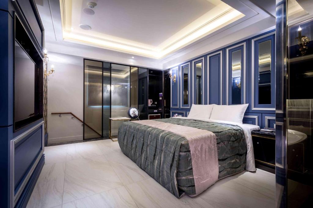 ein Schlafzimmer mit großem Bett und Fernseher in der Unterkunft OUGE Motel - Fengshan in Kaohsiung