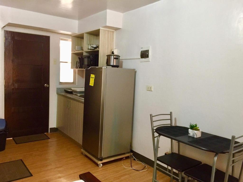 a small kitchen with a table and a refrigerator at BUDGET FRIENDLY CONDO-STUDIO UNIT in Cebu City