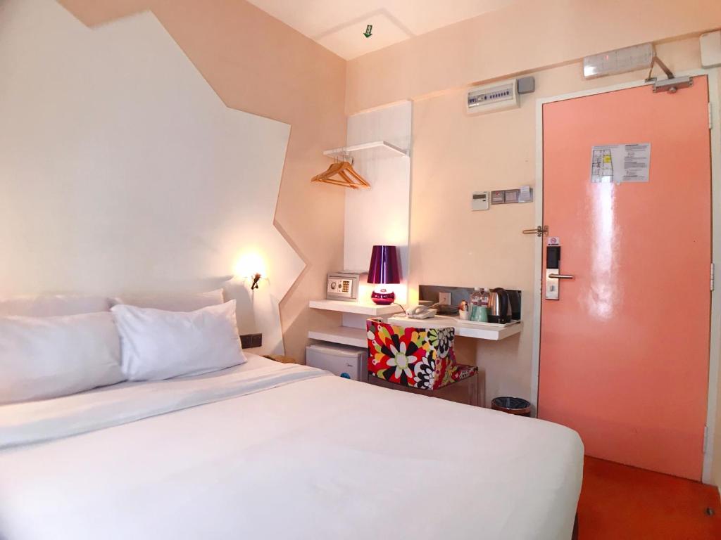 ein Schlafzimmer mit einem weißen Bett und einer roten Tür in der Unterkunft Melange Boutique Hotel Bukit Bintang in Kuala Lumpur