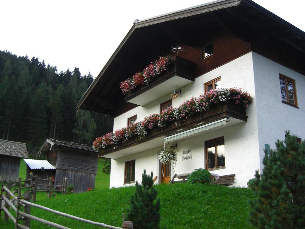 una casa con cajas de flores a un lado. en Payrhof, en Annaberg im Lammertal