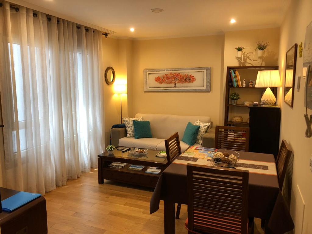 uma sala de estar com uma mesa e um sofá em Céntrico Apartamento. Parking incl. em Vigo