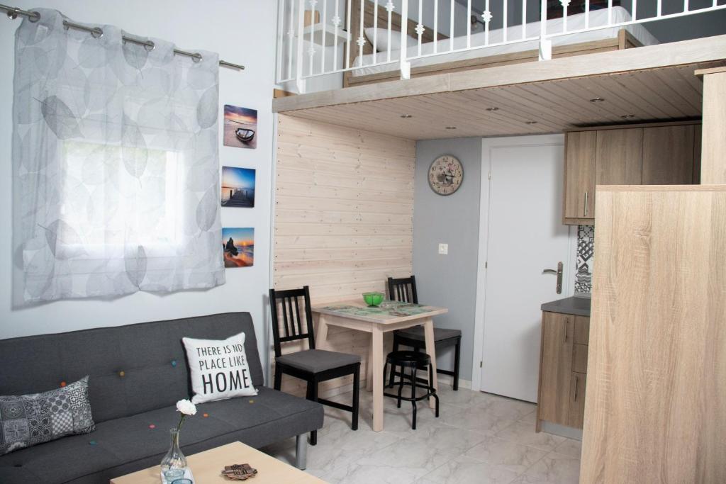 un soggiorno con tavolo e scala di Filippou Luxury Apartments a Flogita